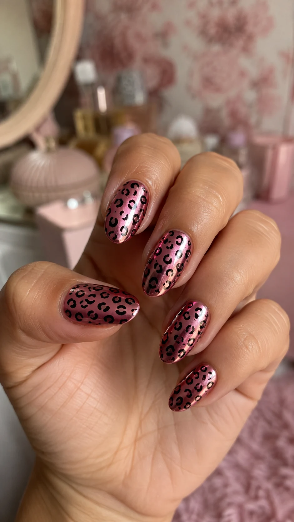 Pink chrome nails with glossy black cheetah spots
