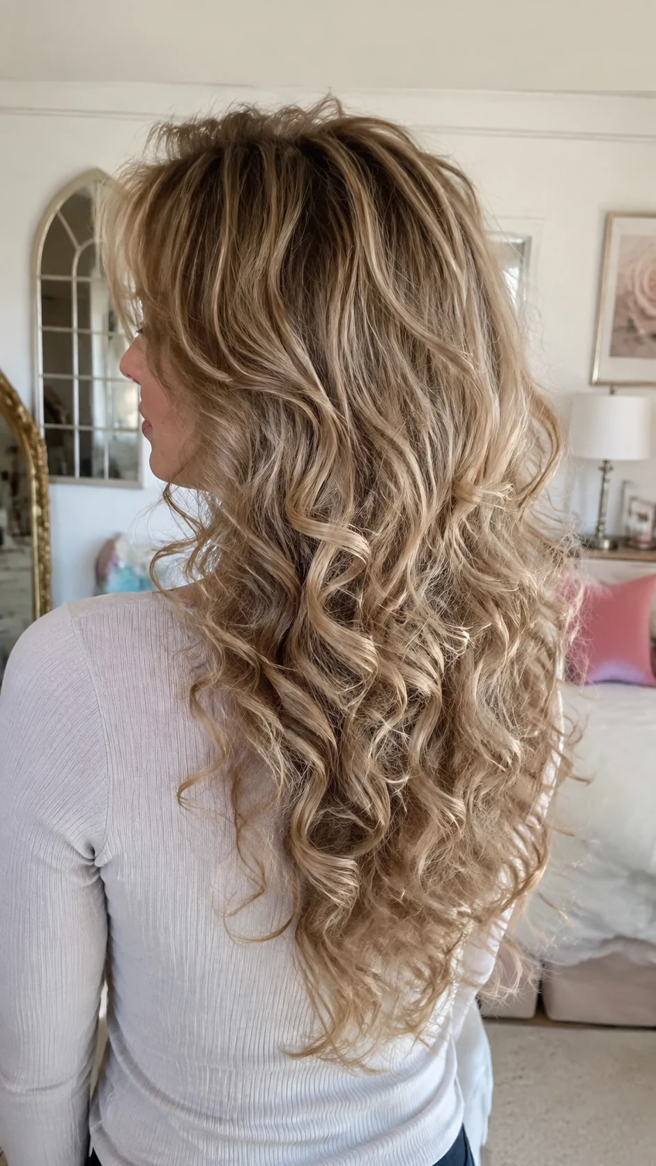 Blonde curly butterfly haircut with curtain bangs and ringlets