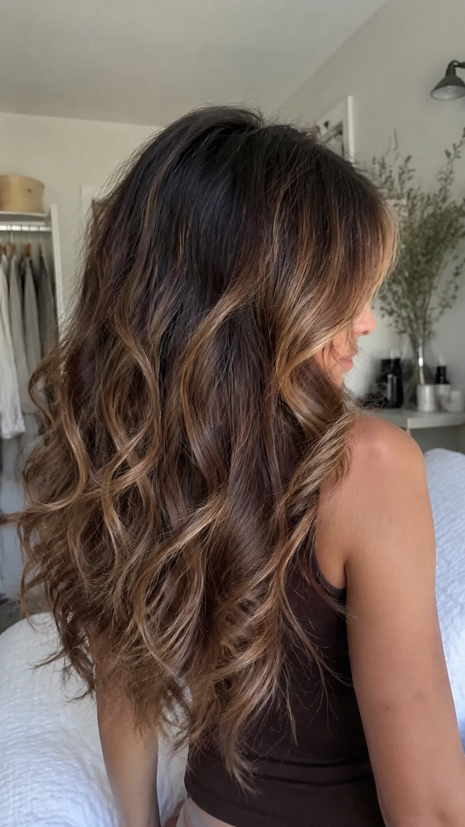 Caramel balayage curly butterfly haircut on long brunette hair