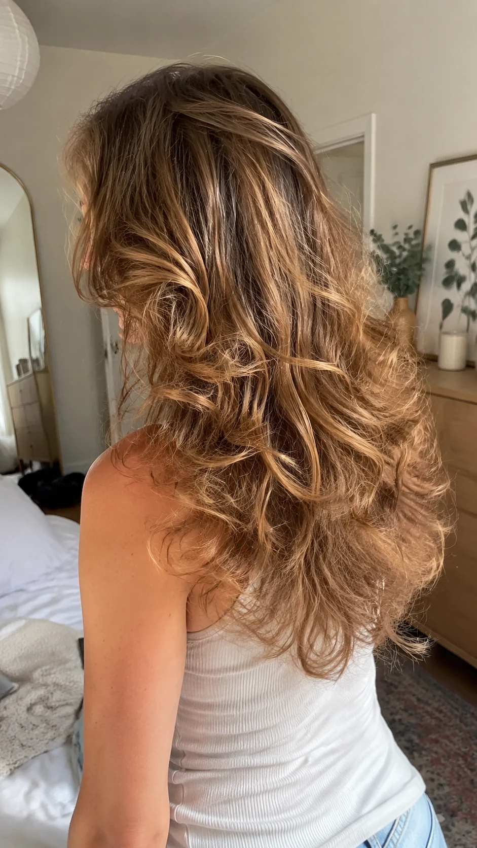 Fine light brown curls in an airy butterfly haircut